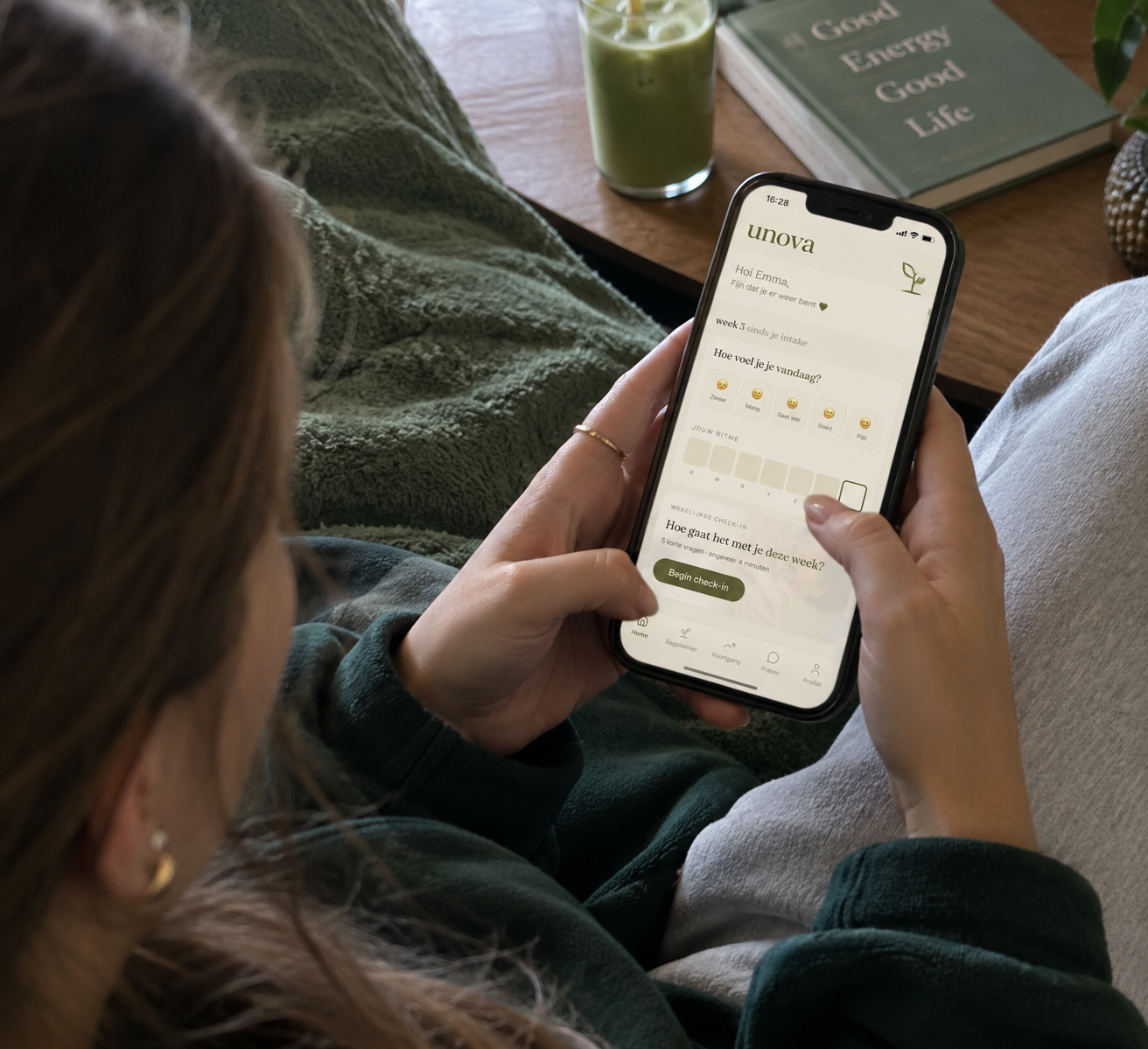 Iemand gebruikt de UNOVA-app op een telefoon, met de persoonlijke wachttijdomgeving zichtbaar op het scherm